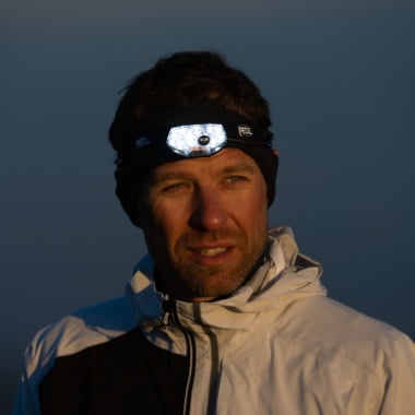 Athlete François D'haene trail running at night with his Petzl NAO RL headlamp.